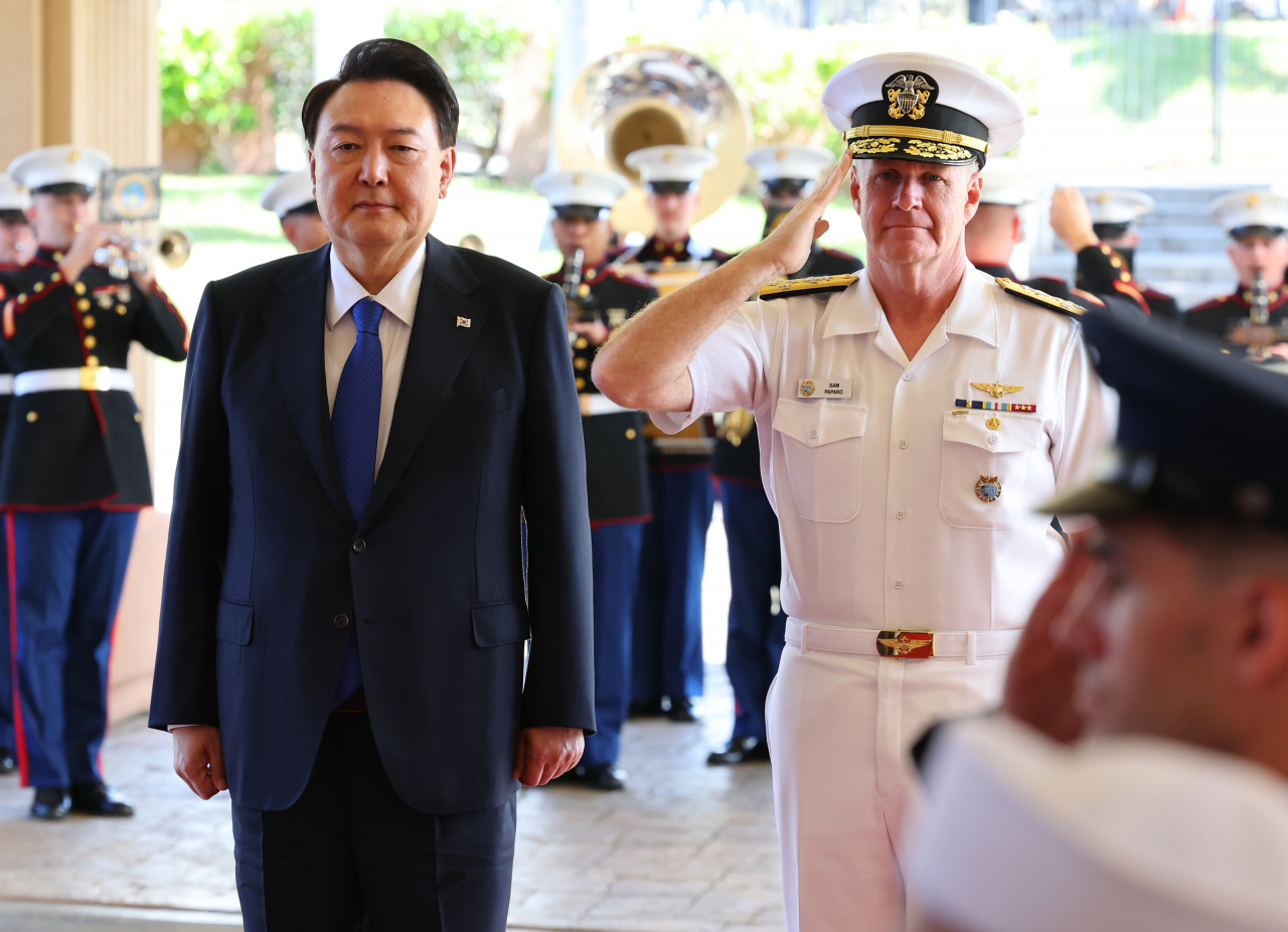 President Yoon Suk Yeol (left) and US Indo-Pacific Command's Commander Adm. Samuel Paparo salute to the national flags during Yoon's visit to US Indo-Pacific Command headquarters in Hawaii on Tuesday. (Yonhap)